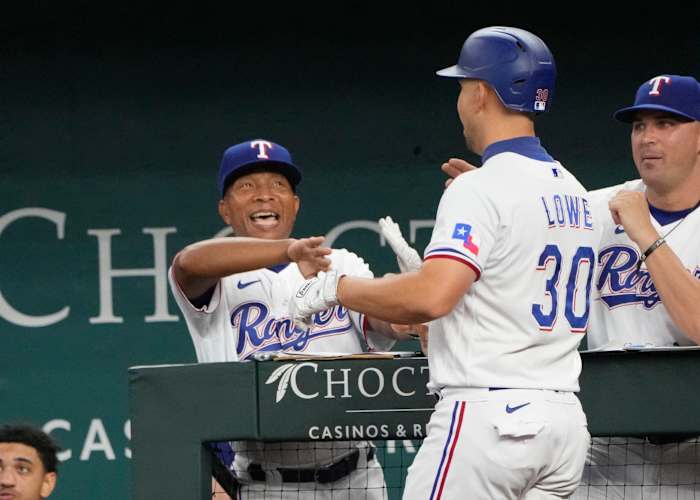 Aug 18, 2022; Arlington, Texas, USA; Texas Rangers first baseman Nathaniel Lowe (30) is congratulated by interim manager Tony Beasley (27) as he arrives to the dugout after hitting a three-run home run against the Oakland Athletics during the fifth inning at Globe Life Field. Mandatory Credit: Jim Cowsert-USA TODAY Sports